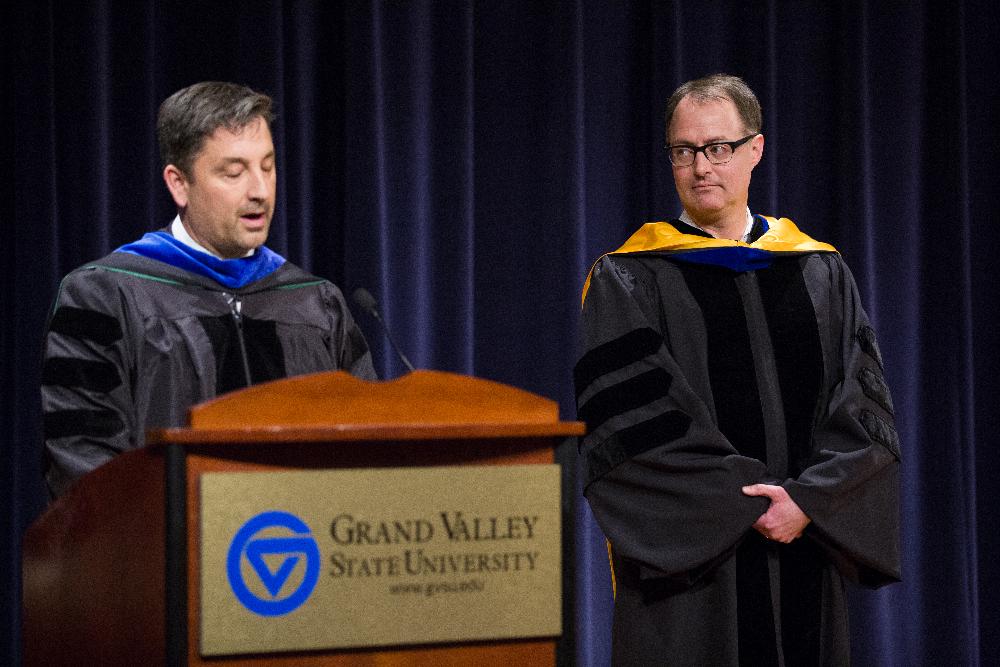 A faculty member listens as a fellow faculty member gives remarks
